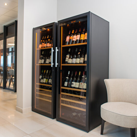 Double cave à vin de service grande capacité installée dans la salle d'un restaurant - Stockage à température de service et belle présentation des bouteilles de vin - Thalasso Resort Valdys