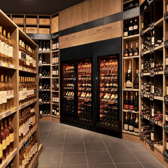 Vitrine à vin installée dans le linéaire d'un rayon en grande distribution. Offre de vin prêts à déguster et sécurisation des bouteilles. EuroCave ShowCave. Leclerc Bourgoin